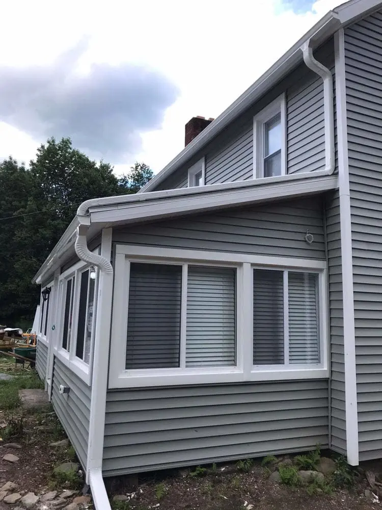 white residential rain gutters on grey house