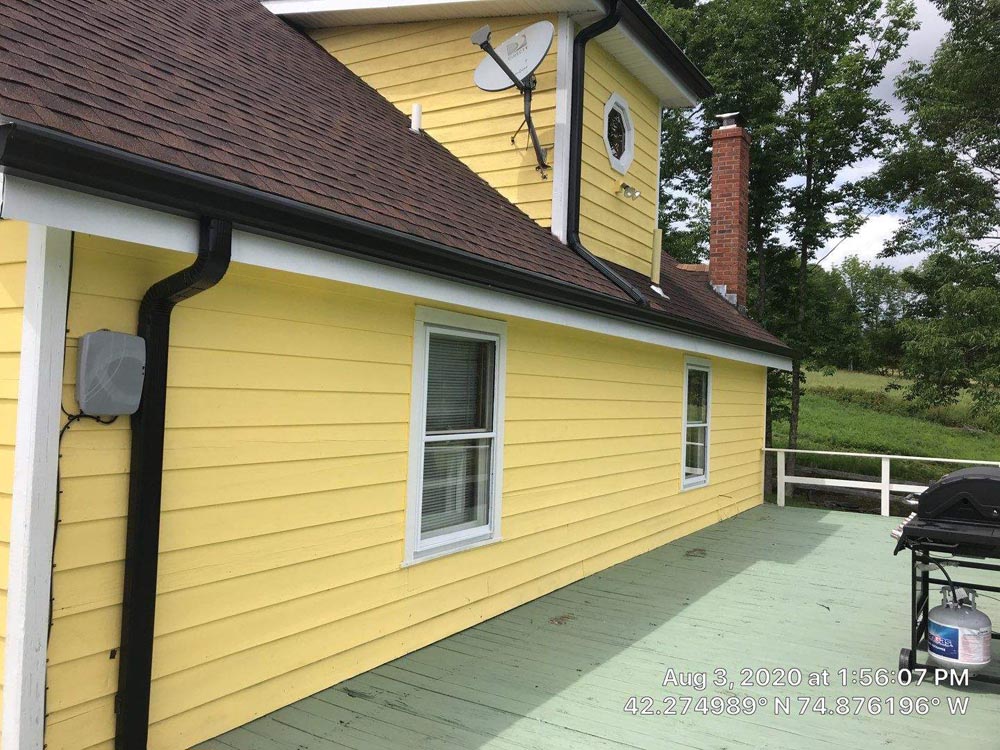 Black Rain Gutters on Yellow Residential Home - Gutter Experts